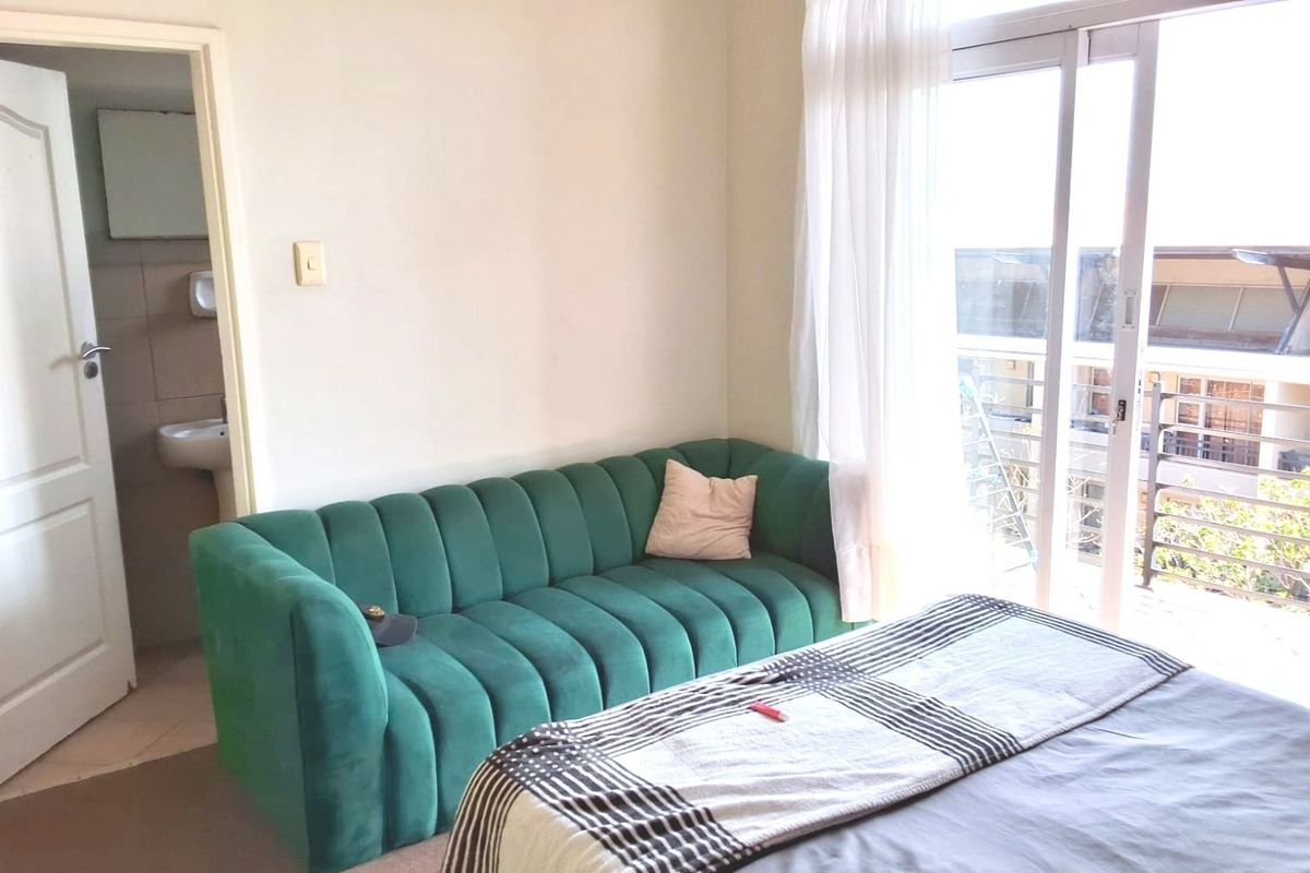 A bedroom featuring a sliding glass door leading to a balcony and direct access to an en-suite bathroom.