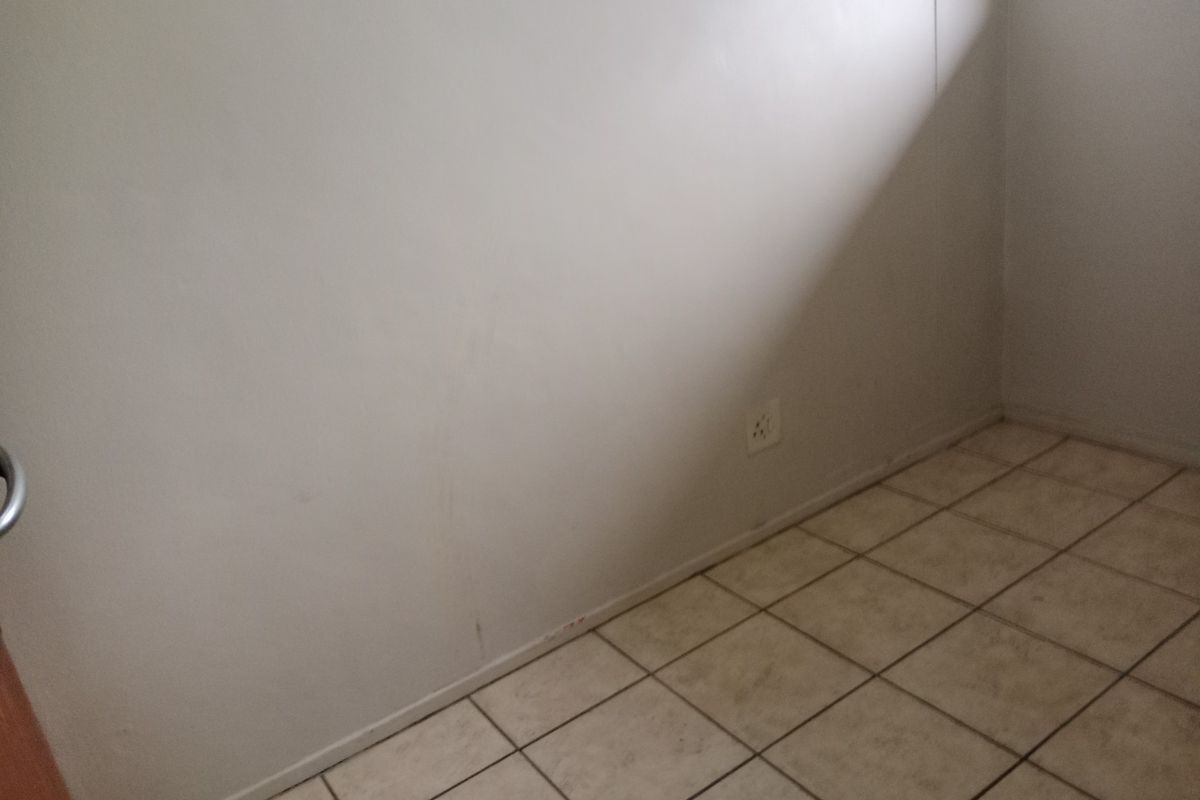 An empty bedroom featuring tiled flooring and a neutral wall finish, ready for personalization.
