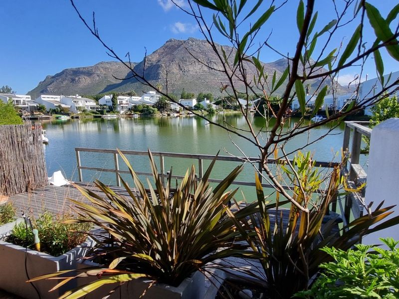 Scenic view of the lagoon and surrounding mountains from a private wooden deck area.