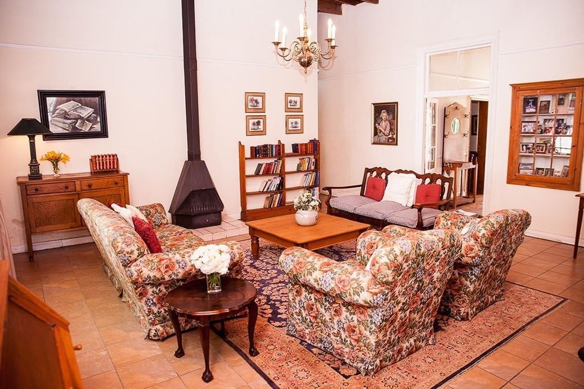 Spacious living room featuring a freestanding fireplace, tiled flooring, and classic architectural details, offering a comfortable and traditional atmosphere.