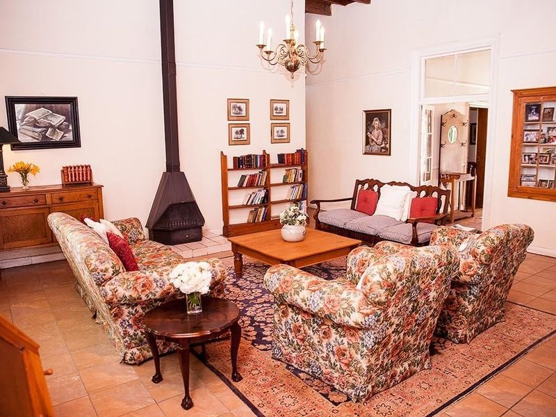 Spacious living room featuring a freestanding fireplace, tiled flooring, and classic architectural details, offering a comfortable and traditional atmosphere.