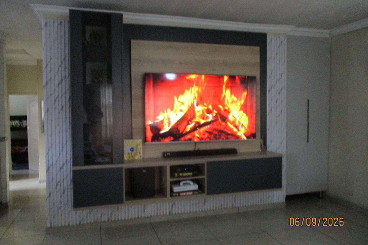 A modern living room featuring a custom built-in media wall with integrated cabinetry and tiled flooring.