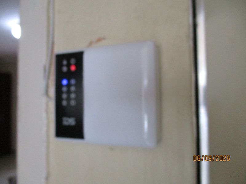 A close-up view of a wall-mounted security alarm system keypad.