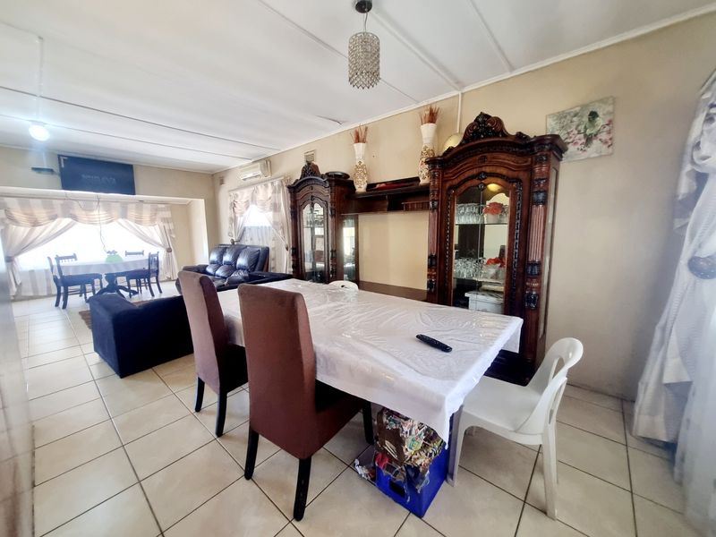 Spacious open-plan living and dining area featuring tiled flooring and an integrated air conditioning unit.
