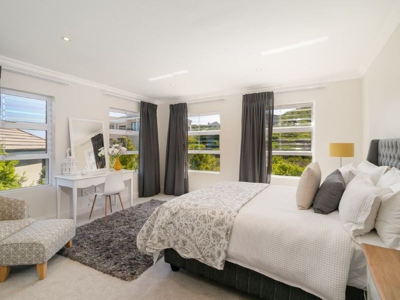 A bright and spacious bedroom featuring recessed downlighting, cornice molding, and multiple louver windows providing natural light and views.