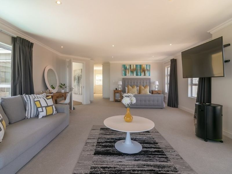 Spacious bedroom featuring neutral carpeting, recessed lighting, and a coved ceiling, offering a comfortable and well-maintained living space.