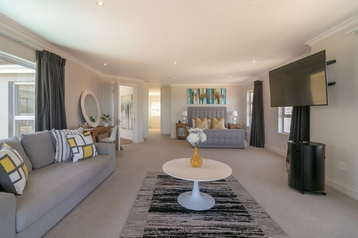 Spacious bedroom featuring neutral carpeting, recessed lighting, and a coved ceiling, offering a comfortable and well-maintained living space.