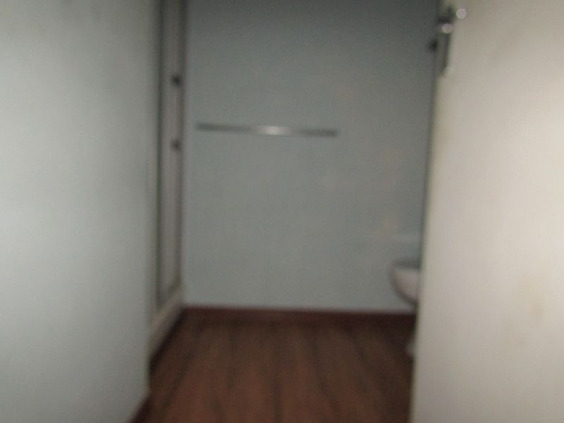 A dimly lit and blurry view of a bathroom featuring a shower enclosure and a wall-mounted towel rail.