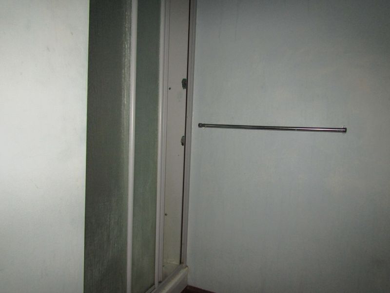A small bathroom area featuring a shower enclosure and a wall-mounted towel rail, requiring cosmetic updates to the wall finishes.