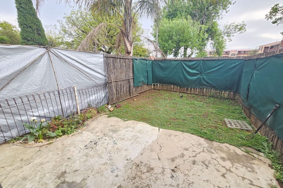 A private rear garden area featuring a concrete patio, small lawn, and perimeter fencing, offering potential for landscaping and outdoor improvement.
