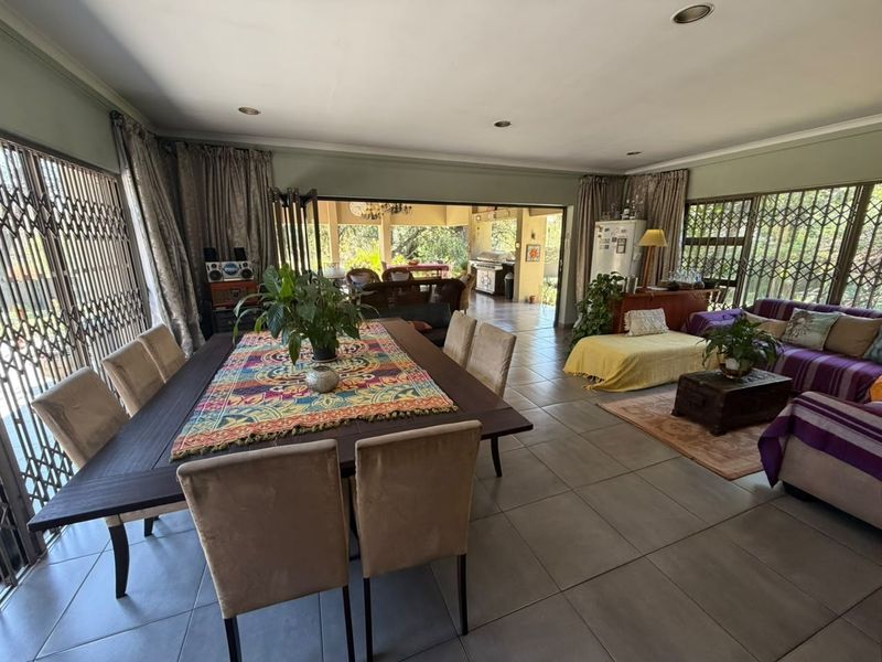 Spacious open-plan living and dining area featuring large sliding doors that provide seamless access to the covered outdoor patio.