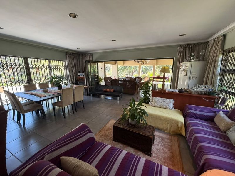 Spacious open-plan living and dining area featuring large sliding doors that open onto a covered patio, providing seamless indoor-outdoor flow.