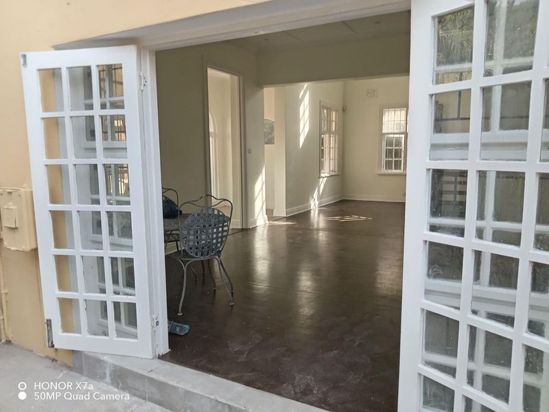 Spacious interior living area featuring polished concrete floors and classic white french doors leading to an outdoor space.