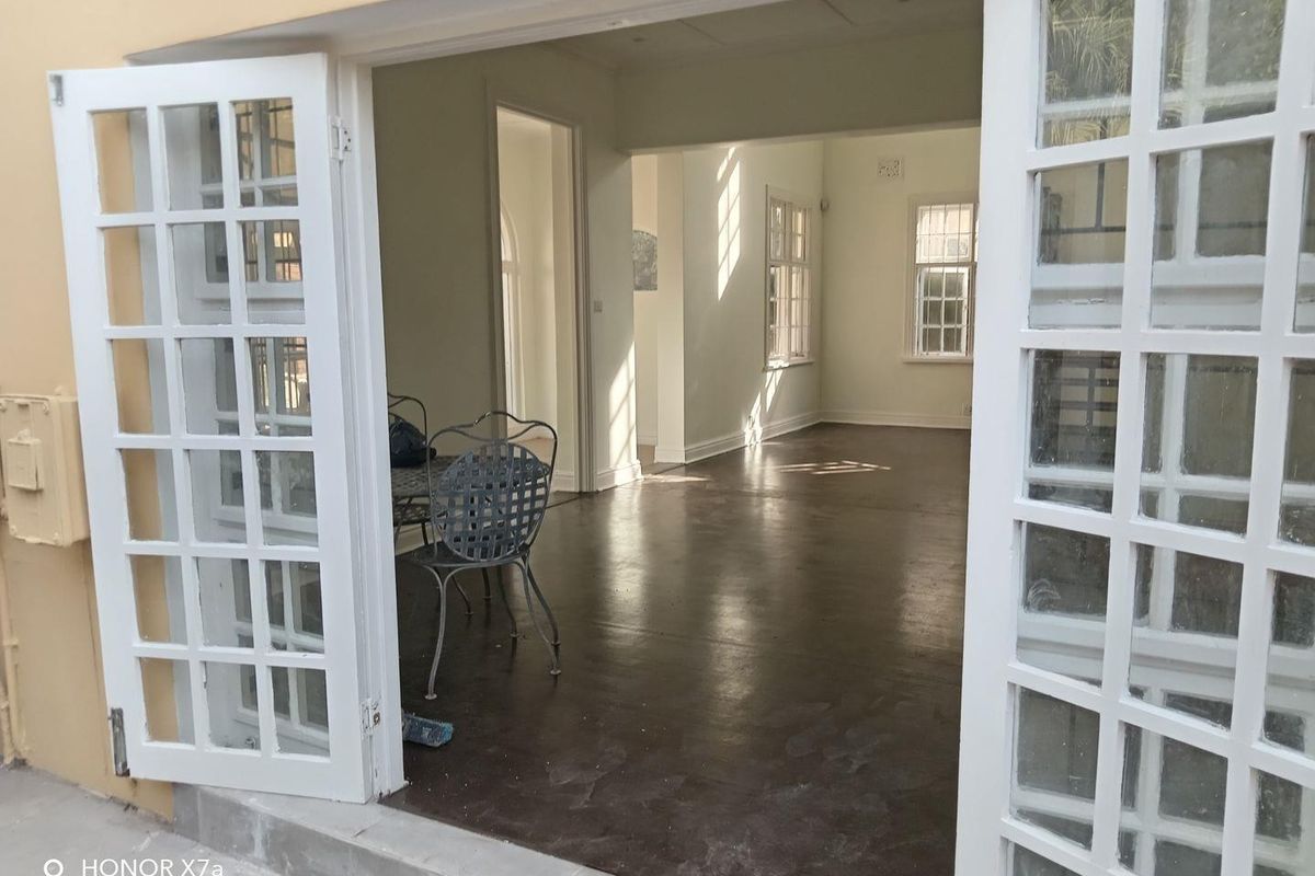 Spacious interior living area featuring polished concrete floors and classic white french doors leading to an outdoor space.