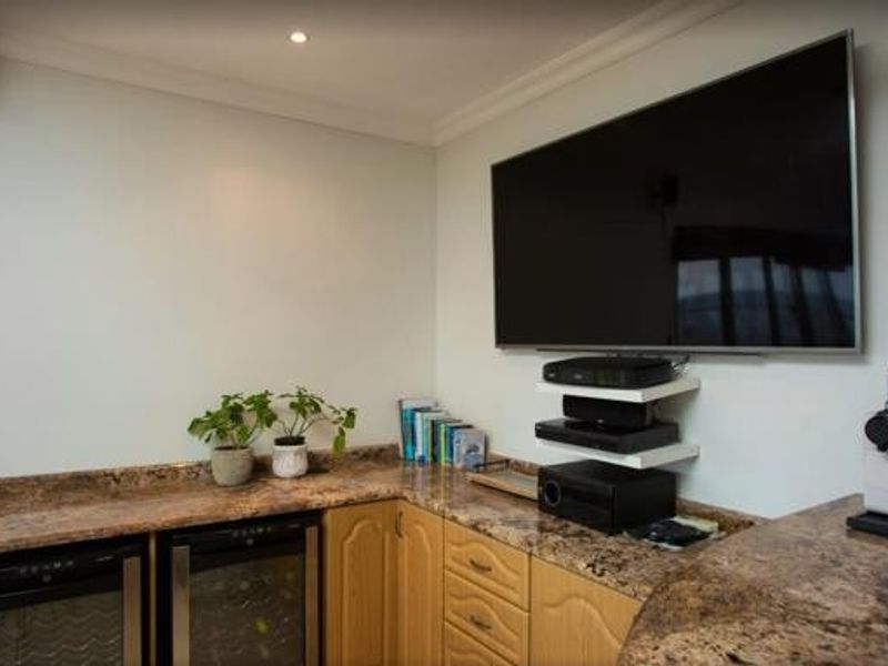A functional living area featuring granite countertops, built-in cabinetry, and an integrated under-counter wine cooler, providing a convenient space for entertainment and storage.