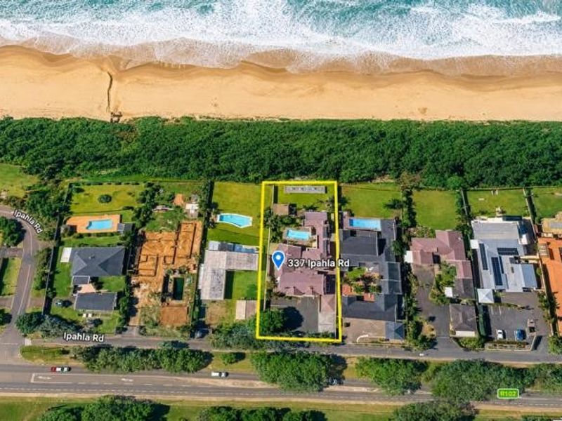 Aerial view of the property highlighting its prime beachfront location, swimming pool, and direct access to the coastline.