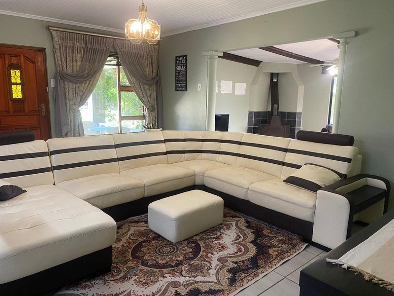 Spacious living room featuring a fireplace, tiled flooring, and decorative columns, offering a comfortable and functional layout for family relaxation.