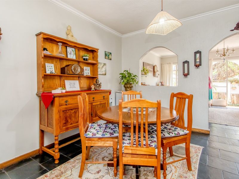 Dining area featuring slate tile flooring, decorative archway, and a pass-through window connecting to the adjacent living space.