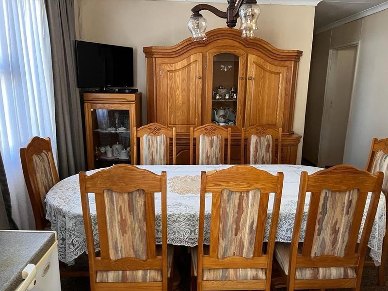 A traditional dining room featuring a central light fixture and coving, providing a functional space for family meals.