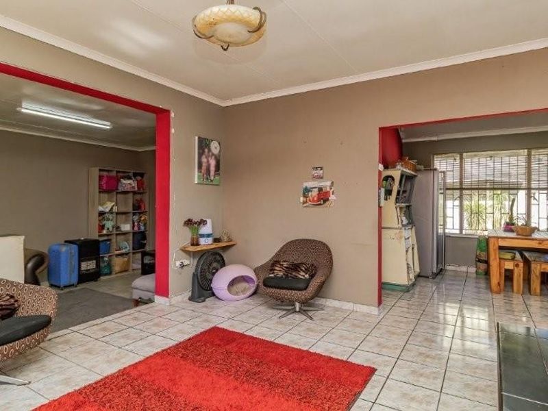 Open-plan living area featuring tiled flooring and large windows, providing a versatile space that connects multiple areas of the home.