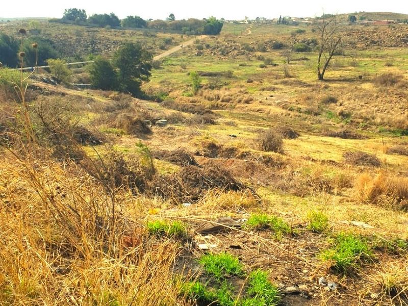 A wide-angle view of the vacant residential land, showcasing the natural topography, dry vegetation, and surrounding landscape.