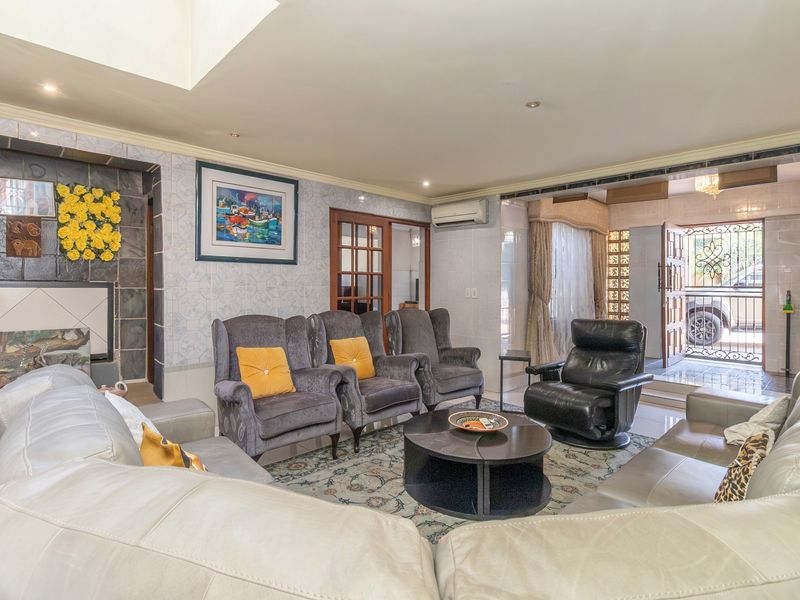 Spacious living room featuring tiled flooring, a stone-clad fireplace, and direct access to the exterior through a secure entrance.