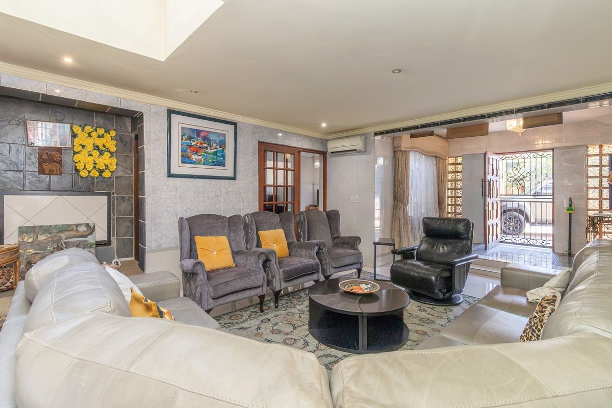 Spacious living room featuring tiled flooring, a stone-clad fireplace, and direct access to the exterior through a secure entrance.