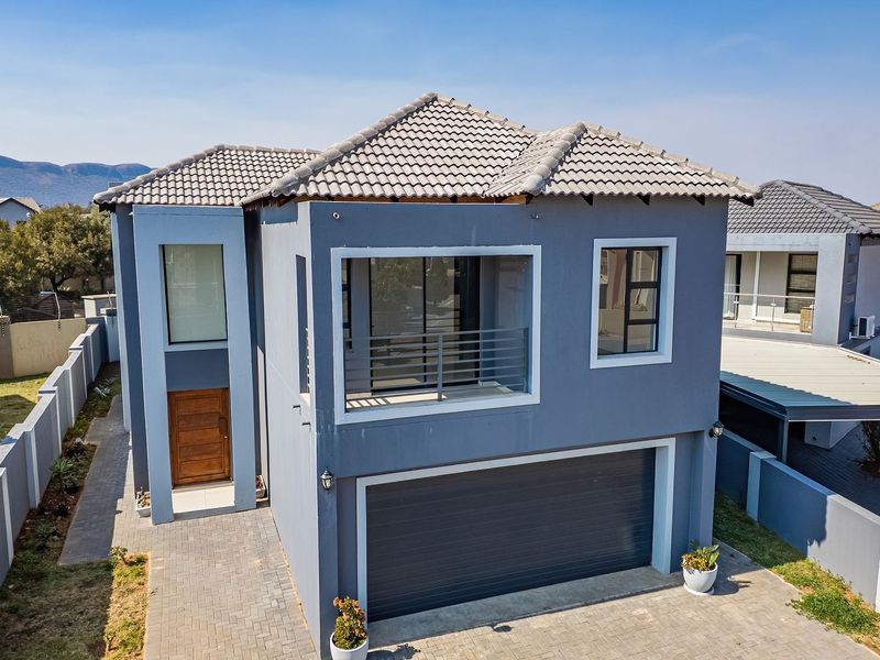 Modern double-story residential home featuring a tiled roof, double garage, and a private balcony, set within a secure estate environment.
