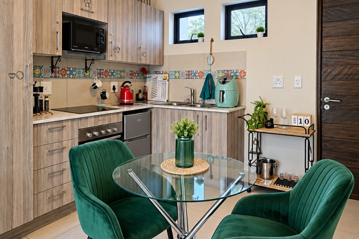A well-maintained kitchen featuring wood-grain cabinetry, integrated appliances, a decorative tiled backsplash, and neutral ceramic floor tiles.