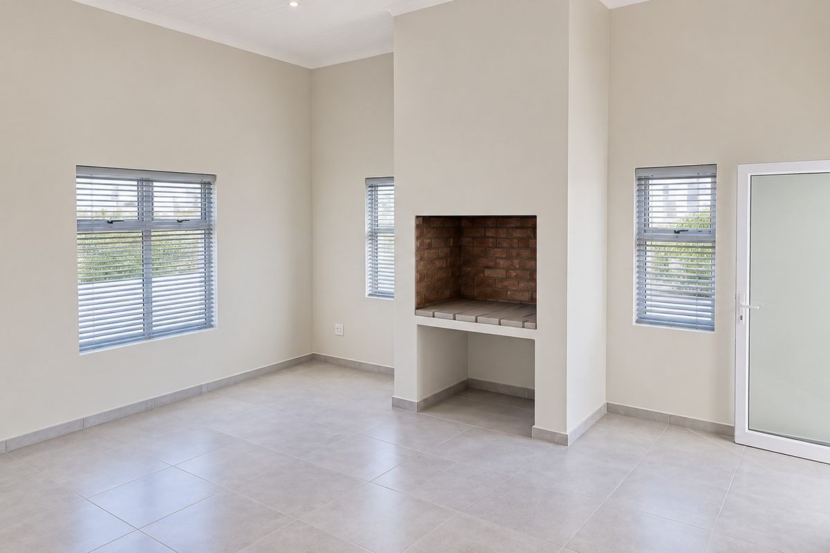 Spacious living area featuring neutral tiled flooring, built-in brick fireplace, and large windows with venetian blinds, offering a bright and clean blank canvas.