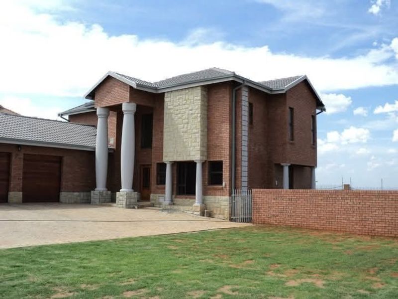 Front elevation of a double-story brick house featuring stone cladding accents, prominent columns, a paved driveway, and an attached garage.