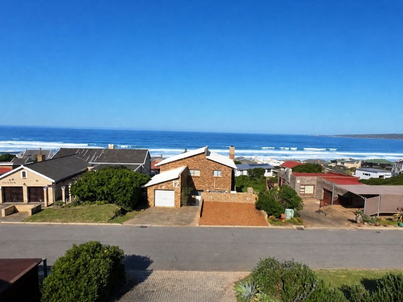An elevated coastal view overlooking a residential street and the ocean horizon.