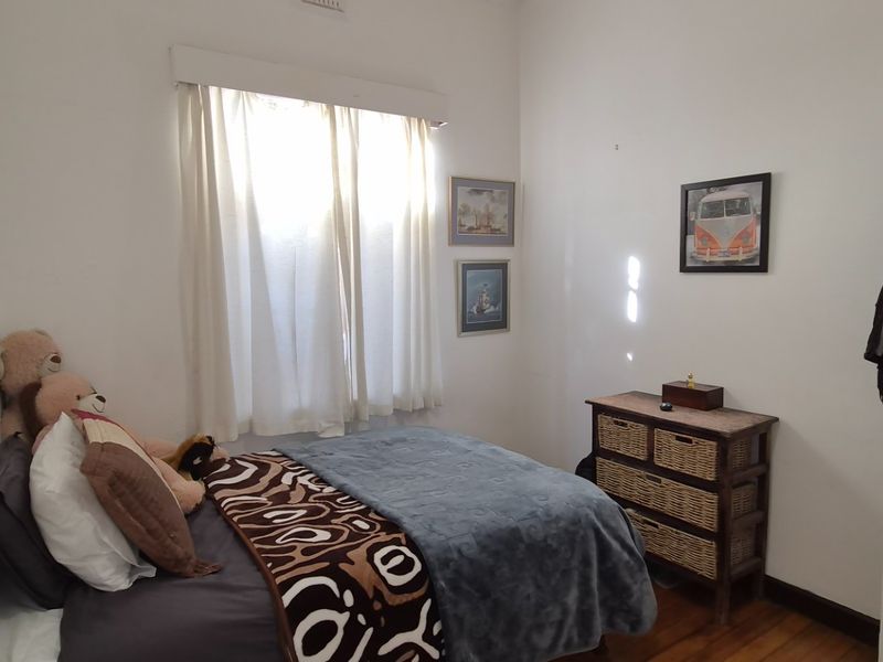 A standard bedroom featuring timber flooring and a classic panel door, providing a functional and neutral space.