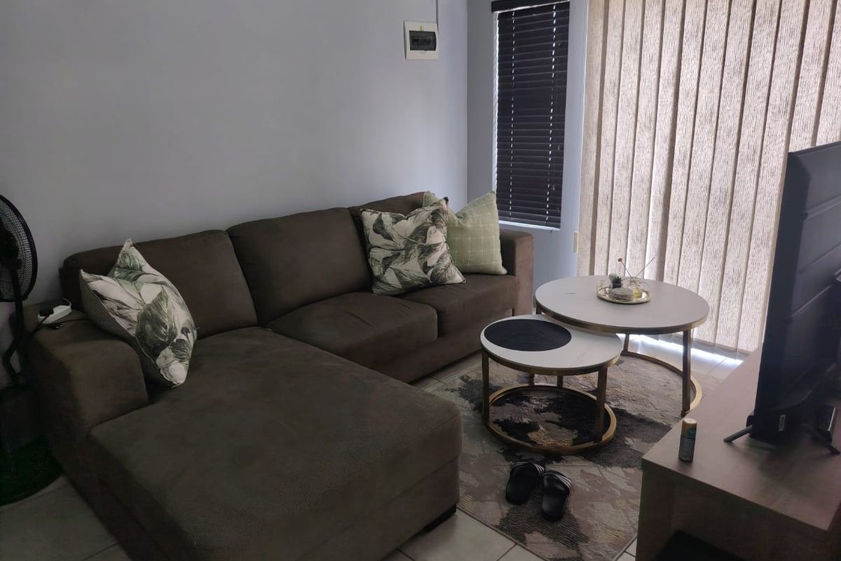 A living room featuring tiled flooring, venetian blinds, and vertical blinds, providing a functional space with natural light access.