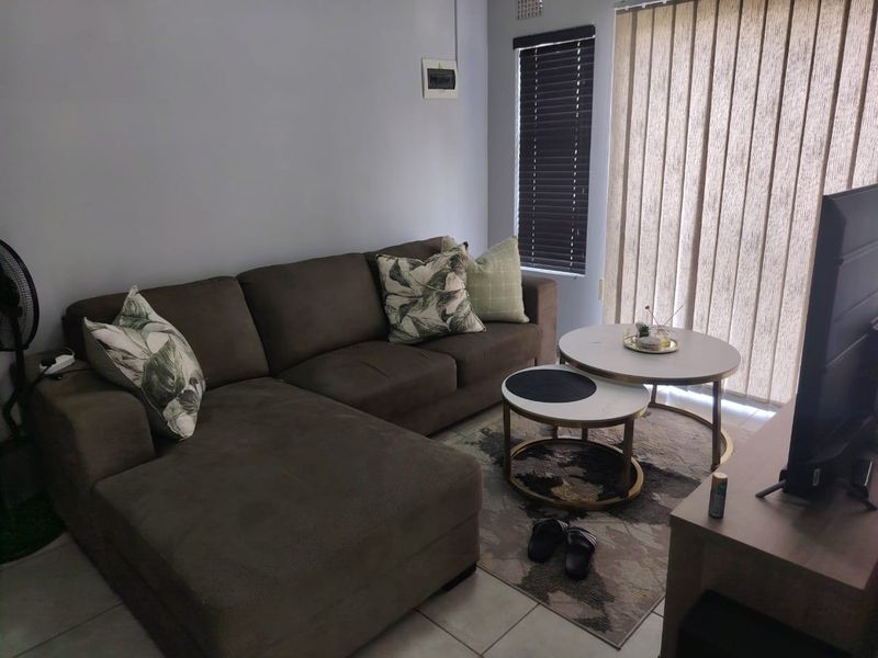 A living room featuring tiled flooring, venetian blinds, and vertical blinds, providing a functional space with natural light access.