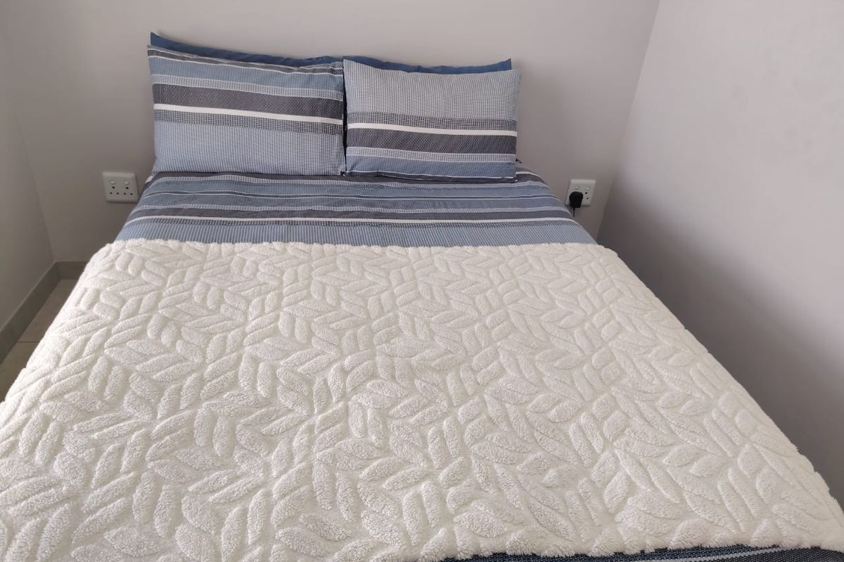 A simple bedroom space featuring neutral wall finishes and accessible electrical power points.