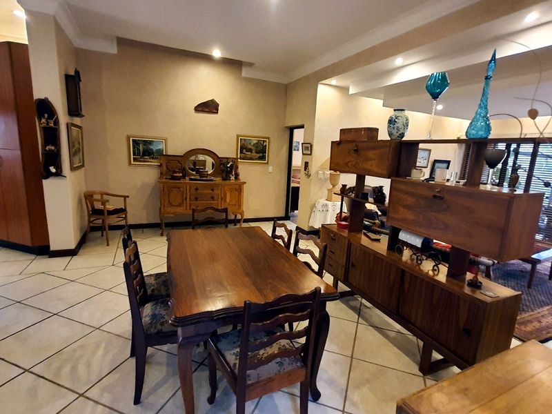 Spacious open-plan living and dining area featuring neutral tiled flooring and recessed ceiling lighting, offering a versatile layout for modern living.