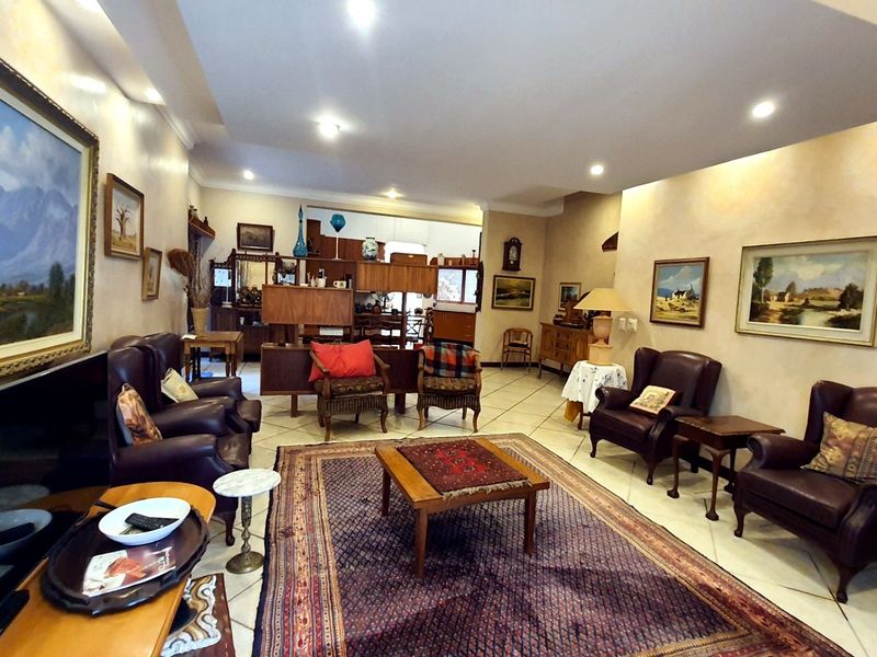 Spacious living room featuring tiled flooring, recessed downlighting, and a coved ceiling, offering a comfortable and well-lit area for relaxation.