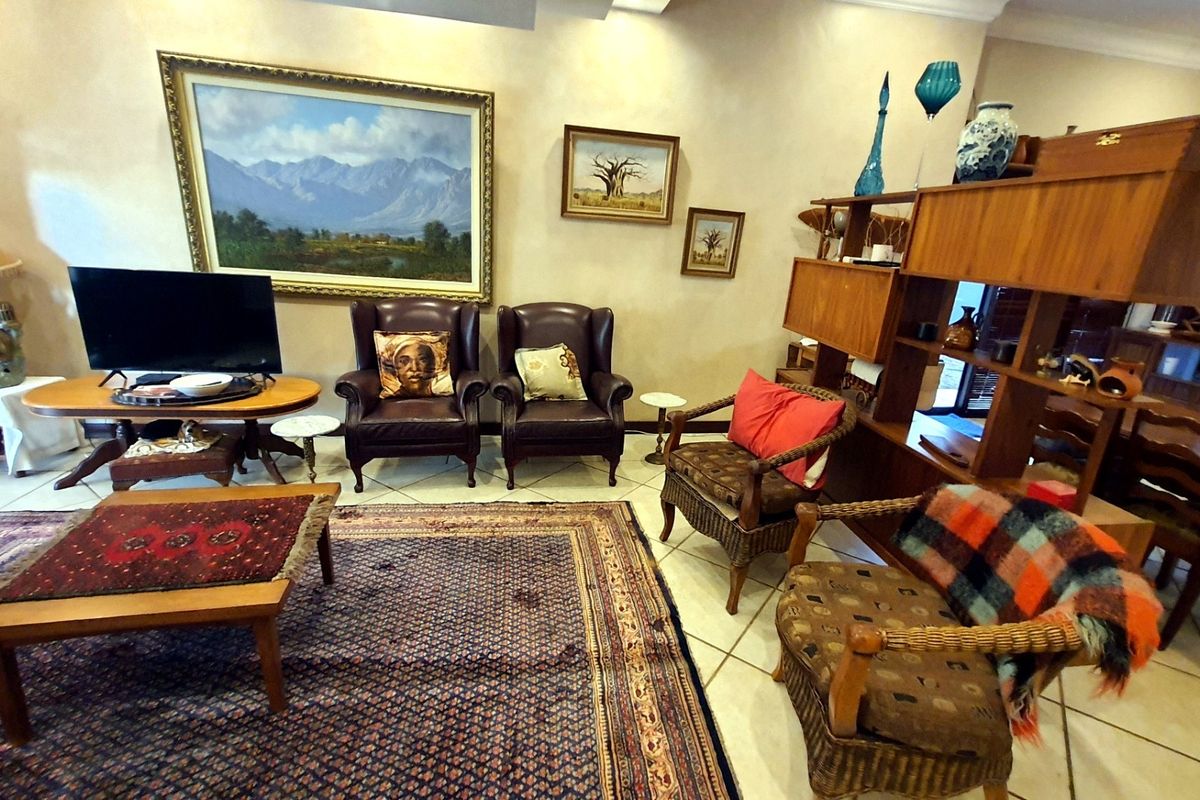 A spacious living room featuring tiled flooring and coved ceiling details, providing a comfortable and traditional living area.