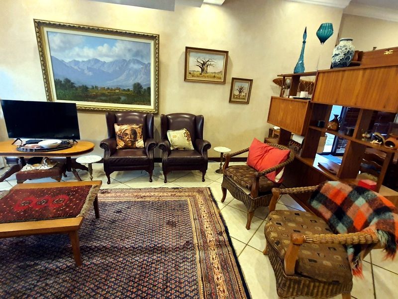 A spacious living room featuring tiled flooring and coved ceiling details, providing a comfortable and traditional living area.