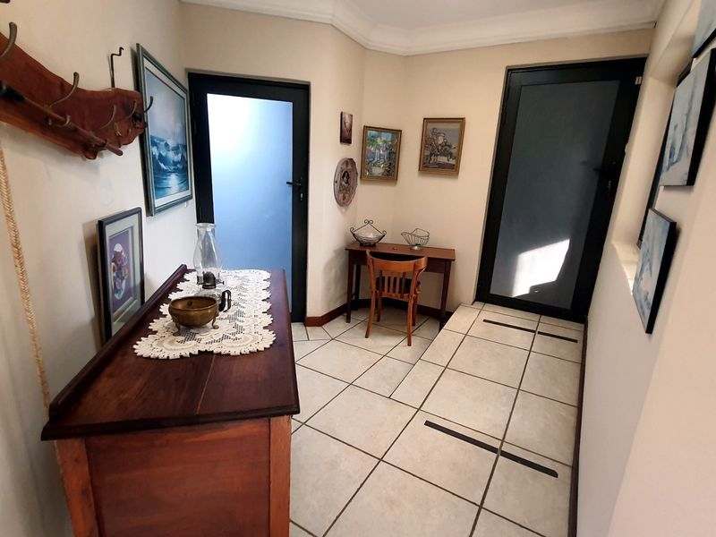 An entrance foyer featuring tiled flooring and modern frosted glass doors, providing a clean and functional transition space for the apartment.