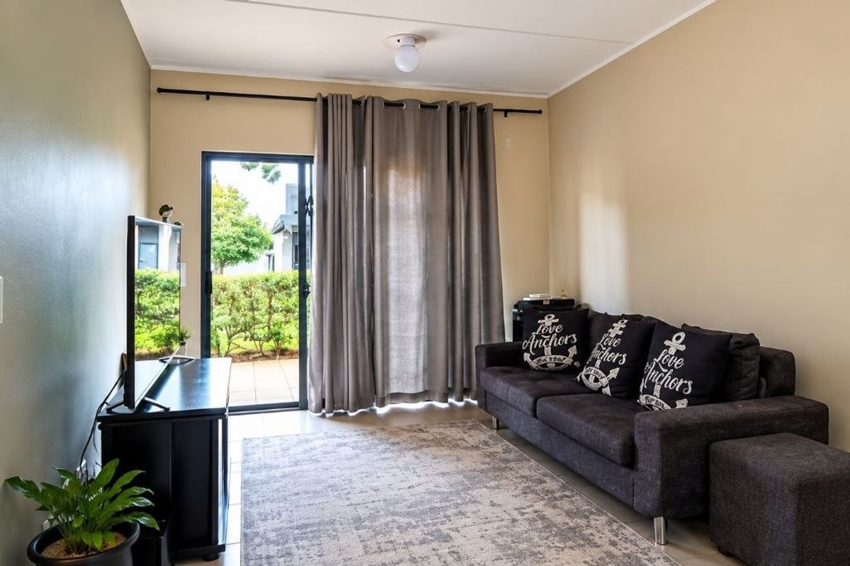 A living room featuring tiled flooring and a sliding glass door providing access to an outdoor area.