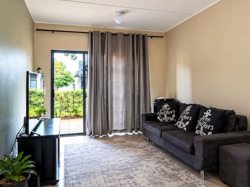 A living room featuring tiled flooring and a sliding glass door providing access to an outdoor area.