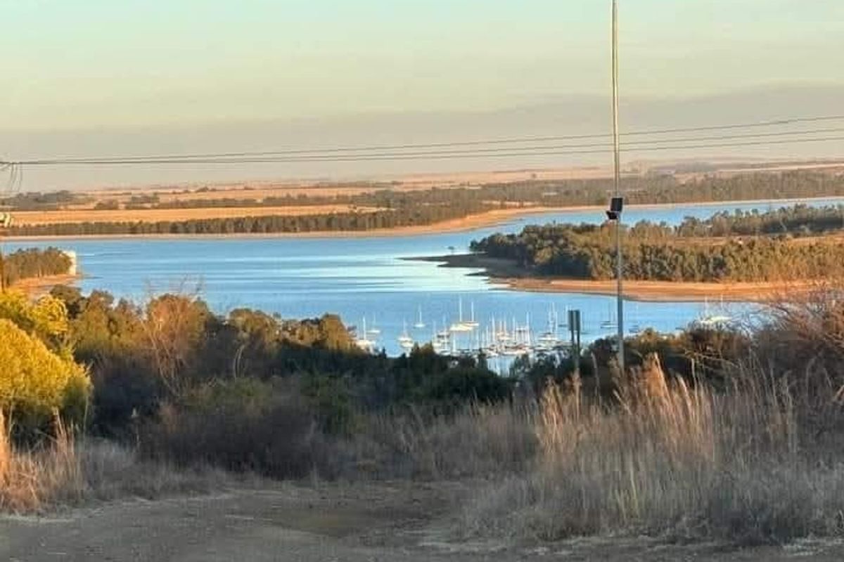 A scenic view overlooking a large dam or lake with a marina and surrounding landscape.