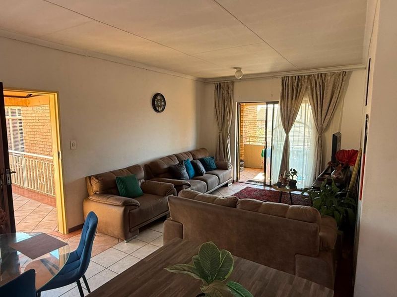 Open plan living area featuring tiled flooring and direct access to an outdoor balcony through sliding glass doors.