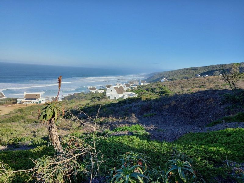 A scenic elevated view overlooking the coastline, ocean, and surrounding residential development in a natural coastal setting.
