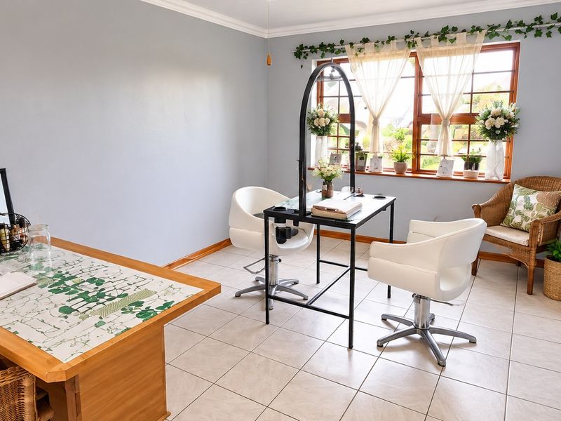 A bright and functional office space featuring neutral tiled flooring, large timber-framed windows, and clean wall finishes, suitable for a home workspace or studio.