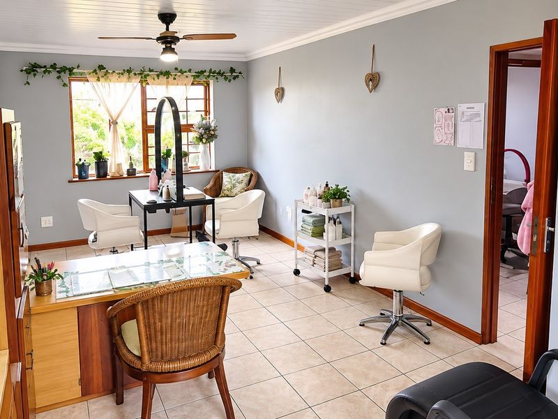 A well-lit room currently utilized as a salon space, featuring tiled flooring, a ceiling fan, and neutral wall finishes.