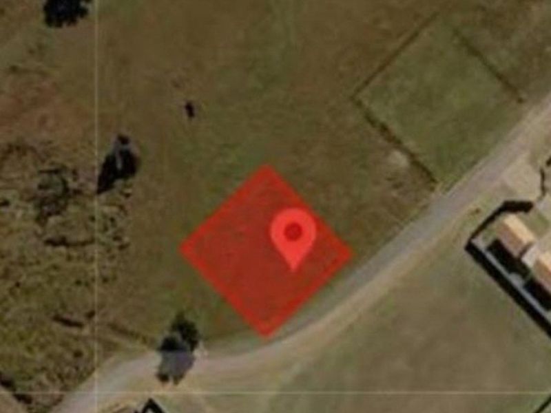 An aerial view of a vacant residential plot of land, showing the site boundaries and surrounding neighborhood context.