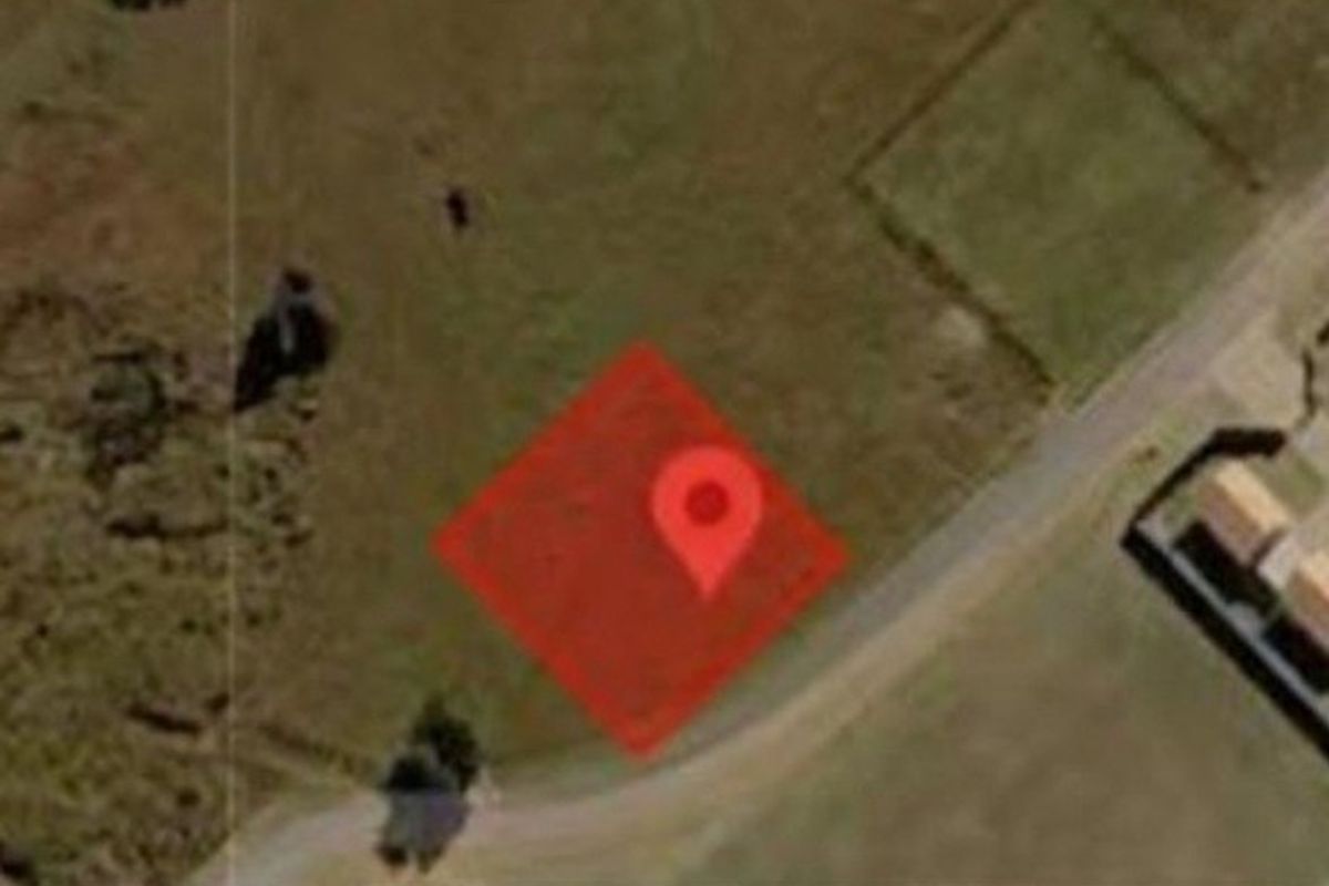 An aerial view of a vacant residential plot of land, showing the site boundaries and surrounding neighborhood context.